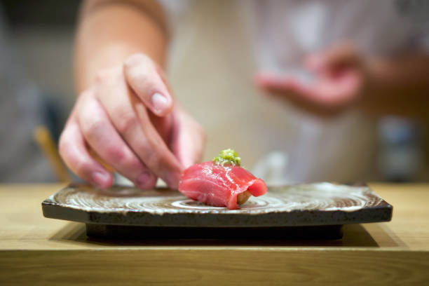新鮮なわさびを入したマグロ寿司をセラミックプレートに盛り付けます。日本の寿司屋でおまかせ体験をお楽しみください。 - 寿司 ストックフォトと画像