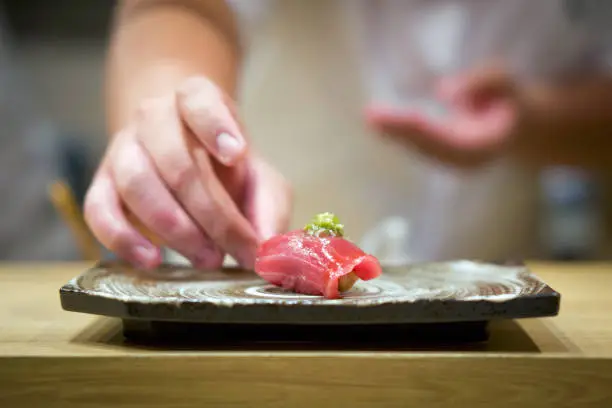 Photo of Tuna Sushi with fresh wasabi served on ceramic plate. Enjoy Omakase experience at Japanese Sushi Restaurant.