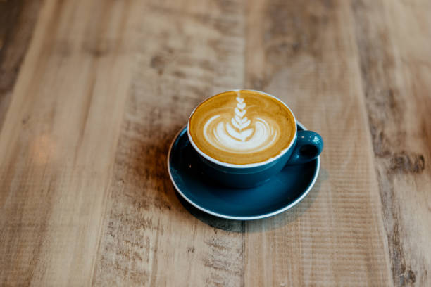 Flat white coffee with froth art on top of wooden table Flat white coffee with froth art on top of wooden table flat white stock pictures, royalty-free photos & images