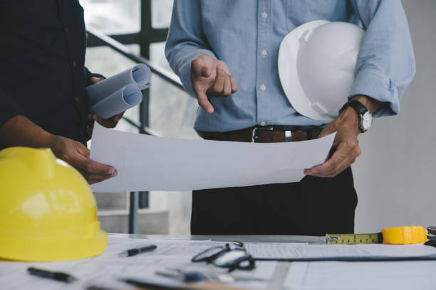istock Architect man Working on Blueprint and Engineers are helping to design work on blueprints . 1357381523
