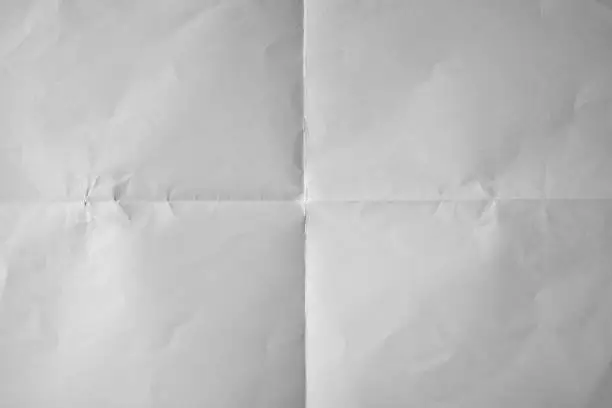 Photo of Uneven white paper folded in four fraction background