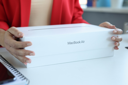 Minsk, Belarus, October 11, 2021:In female hands box from MacBook Air laptop. Expensive gift for a woman concept