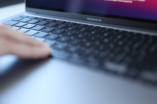 Minsk, Belarus, October 11, 2021: Woman uses an Apple Macbook Air. Laptop for work concept