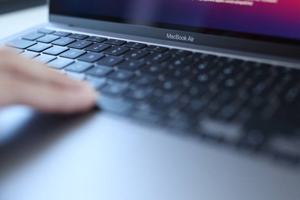 Woman uses an Apple MacBook Air Minsk, Belarus, October 11, 2021: Woman uses an Apple Macbook Air. Laptop for work concept apple keyboard stock pictures, royalty-free photos & images