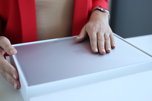 Minsk, Belarus, October 11, 2021: Woman unboxing new MacBook Air, Laptop for work concept