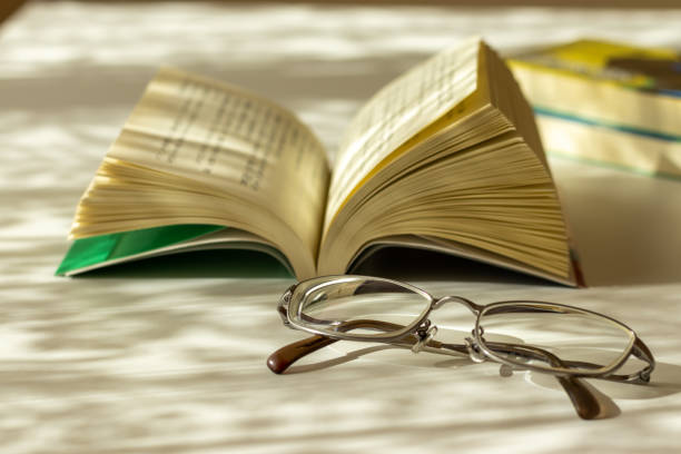 Opened book and eyeglasses on the desk