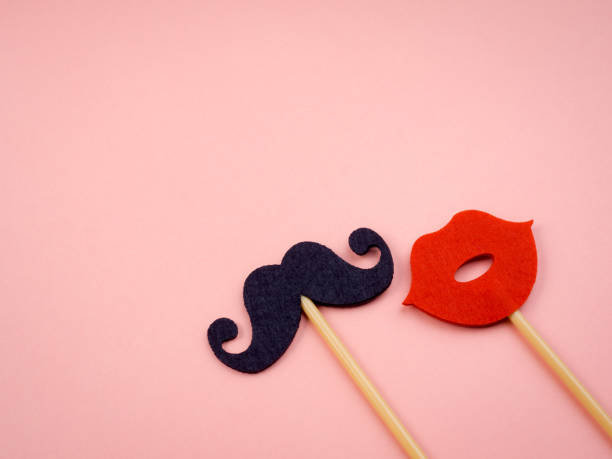 istock Mustache stick and red mouth on stick isolated on pink pastel background with copy space, minimal style. 1357394520