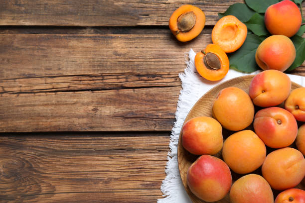 istock Delicious fresh ripe apricots on wooden table, flat lay. Space for text 1357396587
