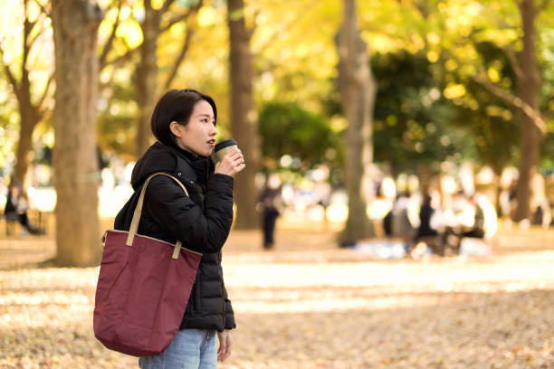 mujer joven bebiendo una taza de té caliente - japanese maple autumn leaf tree fotografías e imágenes de stock