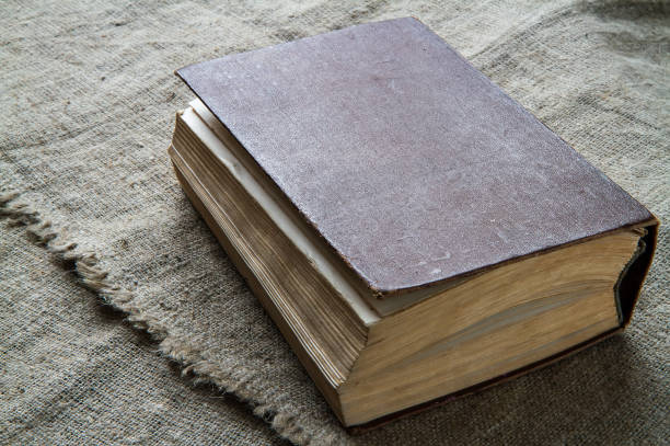 istock An old book against a background of rough fabric. 1357399309