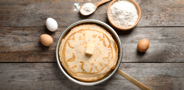 istock Thin pancakes and ingredients on wooden table, flat lay. Banner design 1357399335