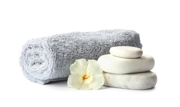 pedras de spa, flor fresca e toalha em fundo branco - massage stones - fotografias e filmes do acervo