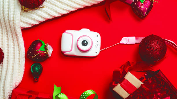 istock flat lay christmas composition with gift toy camera on white background future photographer. gifts for the new year 1357401188