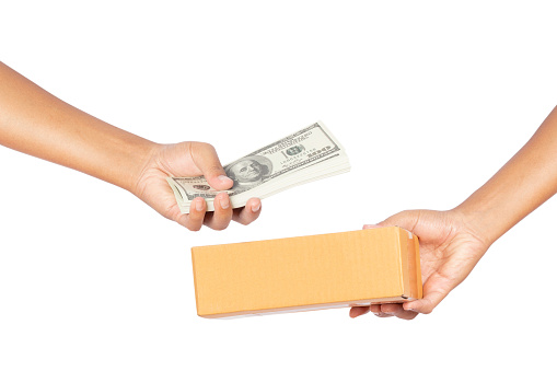 Hand holding cardboard boxes and hand holding dollar money isolated on white background. clipping paths. concept purchase delivery service.