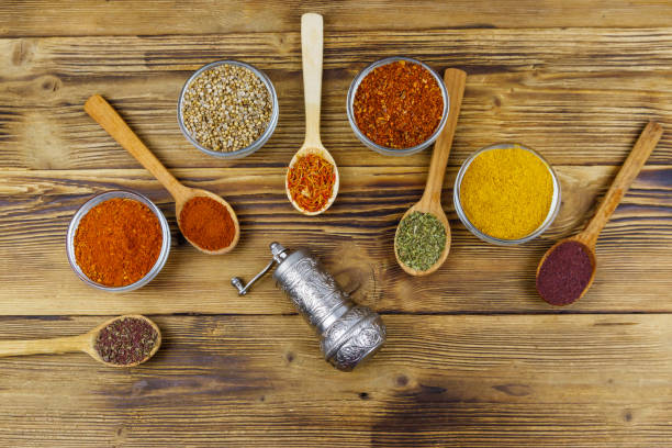Set of different aromatic spices and spice mill on wooden table. Top view stock photo