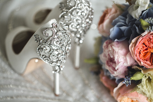 Brides wedding shoes with a bouquet with roses