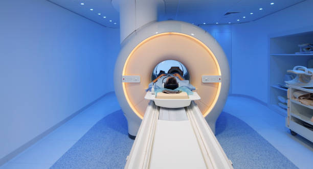 istock Male patient being slide into MRI scanner 1357407560
