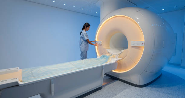 istock Female technologist standing next to the MRI scanner 1357407573