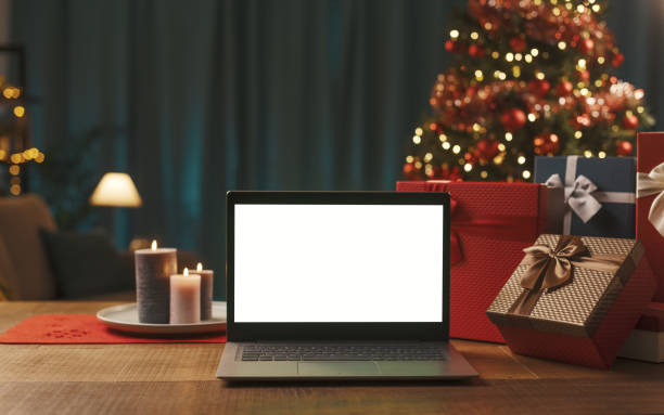 istock Laptop with blank screen, gifts and Christmas tree 1357407676