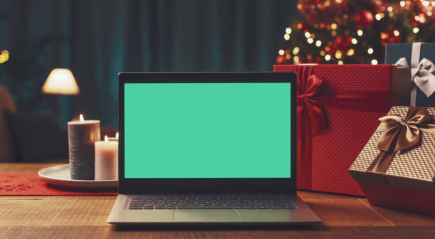istock Laptop with blank screen, gifts and Christmas tree 1357407870