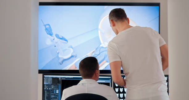 istock Male radiologists looking at the MRI scans on the computer 1357411032