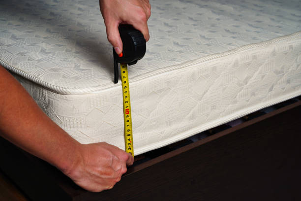 misurare l'altezza del materasso con un metro a nastro. comodo letto ortopedico per dormire. - metro per laltezza foto e immagini stock