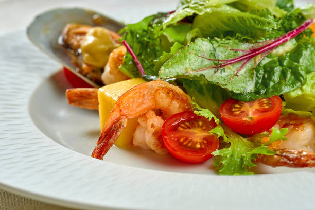 istock Shrimp and mussel salad, mango in a white plate on a tablecloth 1357412746