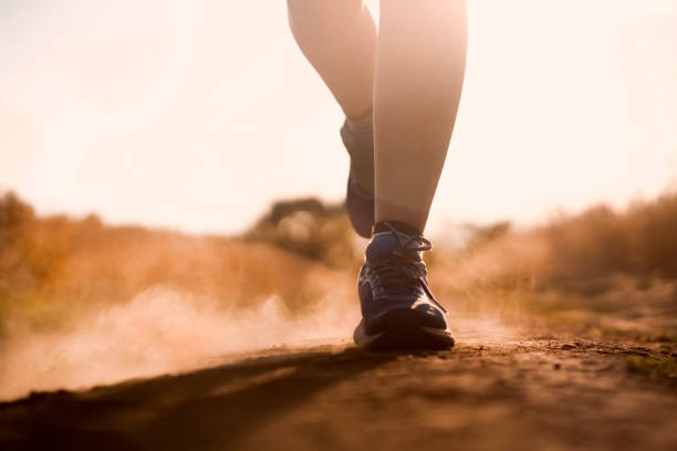 istock Female athletic legs and dust from the trail close up. 1357413569