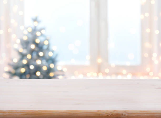 Table with space against blurred Christmas tree and decorated window stock photo