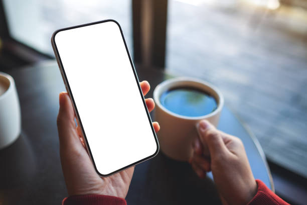 istock a woman holding mobile phone with blank desktop screen while drinking coffee in cafe 1357414681