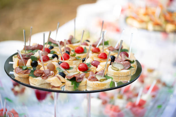 cena a buffet con tavolo di catering, banchetto splendidamente decorato con varietà di diversi snack e stuzzichini per feste di compleanno aziendali o ricevimento di nozze, tartine, salumeria - wedding reception wedding cake wedding cake foto e immagini stock