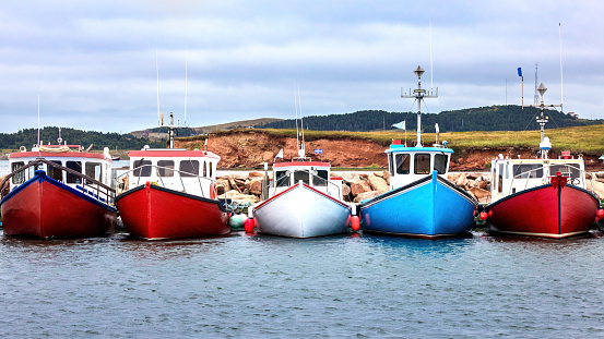A row of colour fishing boats in the harbour of Havre Aubert, Magdalen Islands, Canada. The primary industry of the Islands is its fisheries.