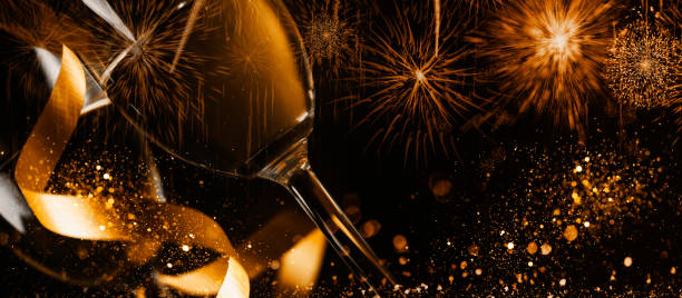 dwa kieliszki do szampana ze złotą wstążką i złotym brokatowym pluskiem bokeh na ciemnym tle. - toast party champagne dinner zdjęcia i obrazy z banku zdjęć