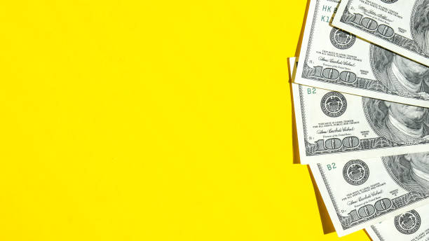 istock Us dollar bills in creative layout. Business concept, development perspective. Flat lay. Top view. Minimal creative style pattern. Copy space. Yellow background 1357422661