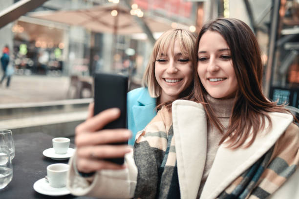 istock Selfie By Smiling Female Friends Outside While Enjoying Coffee 1357424246
