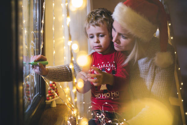 istock Little boy draws on a window in the winter 1357425800