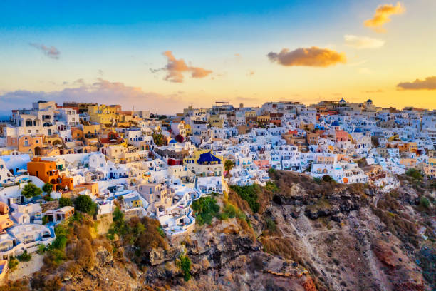 Aerial drone view of famous Oia village with white houses and blue dome churches during sunrise on Santorini island, Aegean sea, Greece. Aerial drone view of famous Oia village with white houses and blue dome churches during sunrise on Santorini island, Aegean sea, Greece cyclades islands stock pictures, royalty-free photos & images