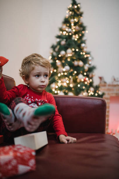 istock Surprised little boy opening Christmas present 1357426541