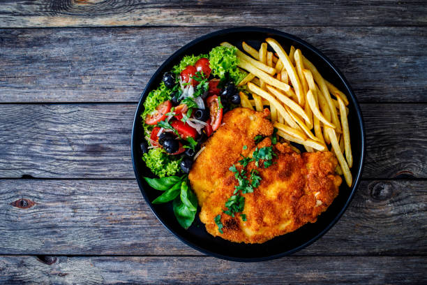 fried pork chop with french fries and fresh vegetable salad on wooden table - schnitzel cutlet food meal imagens e fotografias de stock