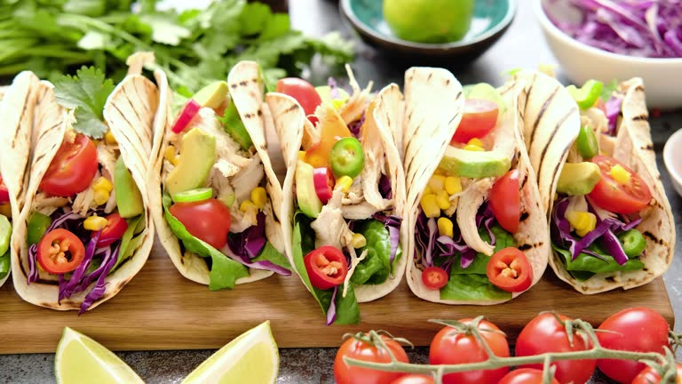 Chicken tacos with grilled meat, avocado, fresh vegetable salad and sauce salsa