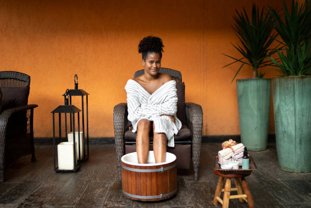 Portrait of a young woman doing a foot treatment at a spa Portrait of a young woman doing a foot treatment at a spa foot spa treatment stock pictures, royalty-free photos & images