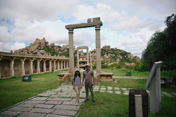 istock Couple standing in front of the beautiful ancient stone structures at Chitradurga fort 1357433065
