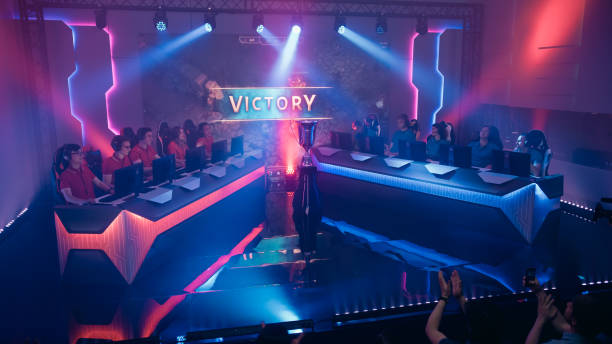 two esport teams of pro gamers play in rpg strategy video game on a championship arena, team wins round and celebrates with high-fives.big screen showing victory sign. cyber games tournament event - esport audience bildbanksfoton och bilder