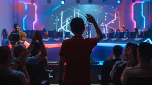esport professional gamer enters video game championship arena. cyber games tournament event with crowd of fans and spectators cheering for favourite players. online streaming entertainment - esport audience bildbanksfoton och bilder