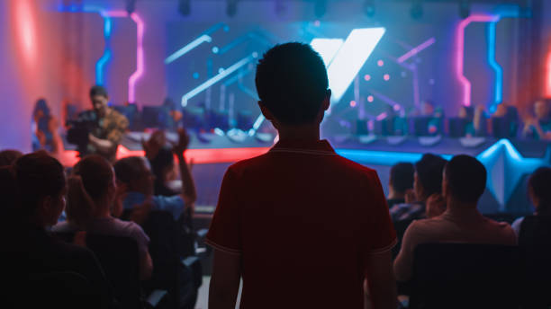 esport professional gamer enters video game championship arena. cyber games tournament event with crowd of fans and spectators cheering for favourite players. online streaming entertainment - esport audience bildbanksfoton och bilder