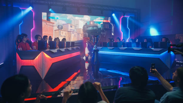 two esport teams of pro gamers play in fps shooter video game on a championship arena with big screen showing mock-up gameplay. cyber games tournament event with competing players, spectators cheer - esport audience bildbanksfoton och bilder