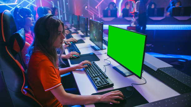 istock Pro Girl Plays Computer Game with Green Screen Display on a Championship. Diverse Esport Team of Pro Gamers Play in Mock-up RPG Strategy Video Game. Stylish Neon Cyber Games Arena. Side View 1357434511