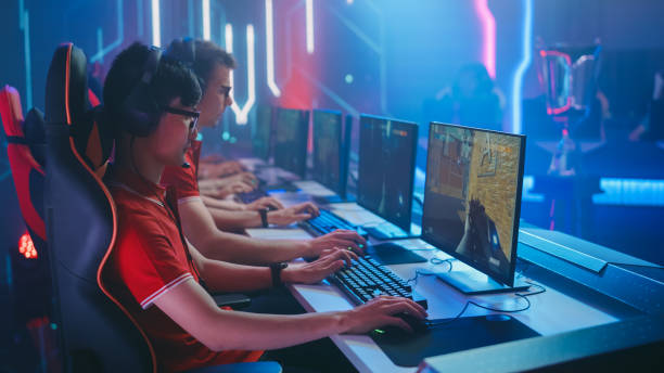 team esport diversificato di giocatori professionisti gioca in mock-up fps shooter video game su un campionato. elegante neon cyber games arena. trasmissione online dell'evento del torneo. - facilities protection services foto e immagini stock