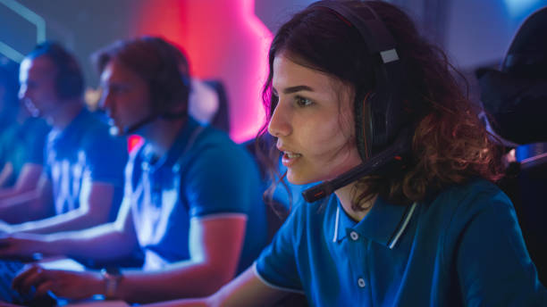 istock Pro Girl Plays Computer Video Game Talking into Headset on a Championship. Diverse Esport Team of Pro Gamers Play in Mock-up Video Game. Stylish Neon Cyber Games Arena. Portrait Shot 1357434532