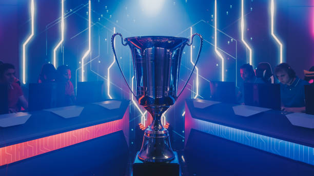two esport teams of pro gamers play to compete in video game on a championship. stylish neon cyber games online streaming tournament arena with trophy in the center. - esport audience bildbanksfoton och bilder
